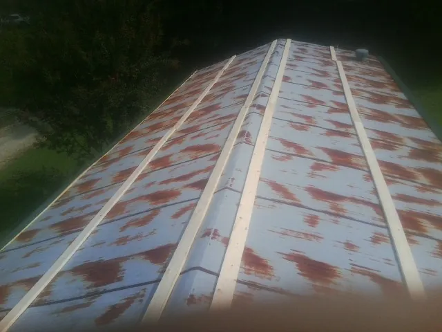 Rusted metal roof panels with new wood purlins before replacement — Storm Damage Roof Repair in Burr Hill by Roofing Brothers