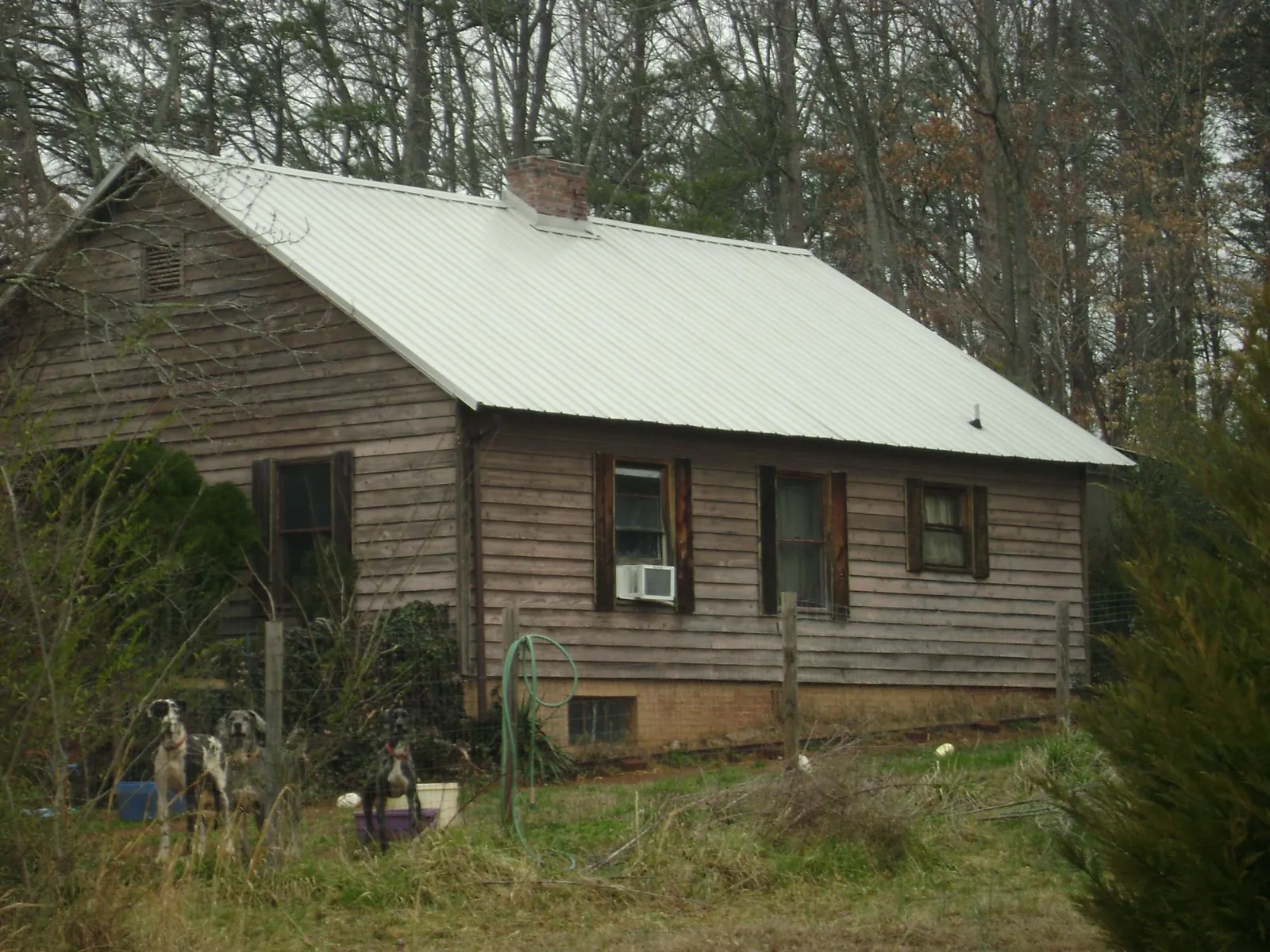 White metal roof on an old wood sided farmhouse, from a Asphalt Shingle Roof Repair job in Burr Hill
